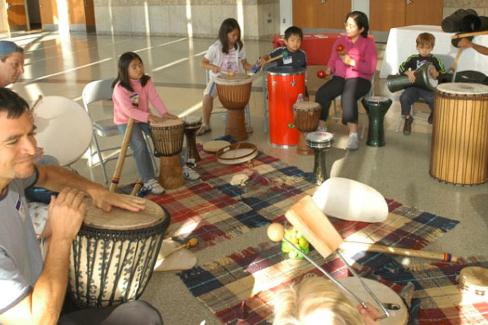 Participants of the Multicultural Drumming Workshop sitting in a semi circle with drums